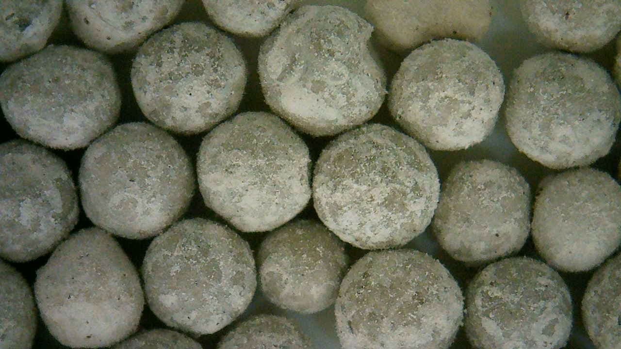 Close-up of spent adsorbent beads showing fouling and structural change after service